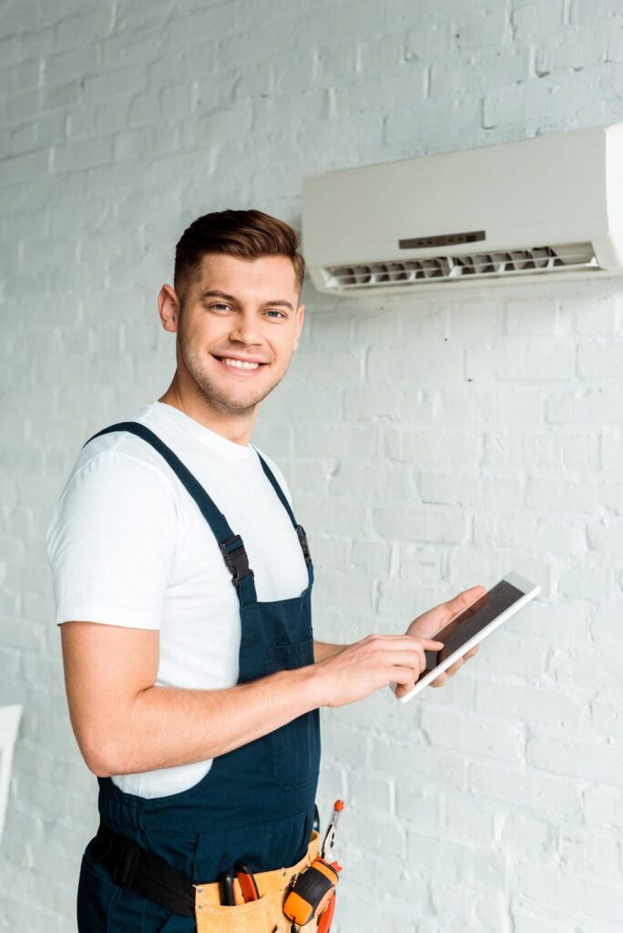 Technicien Oégaz avec tablette près d'une climatisation